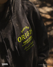 Load image into Gallery viewer, Black hoodie with &#39;Dragon&#39;s Milk&#39; branding on a blurred natural background

