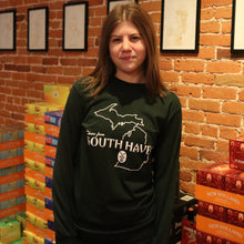 Load image into Gallery viewer, Person wearing a hoodie with a map design in front of a brick wall with framed pictures.
